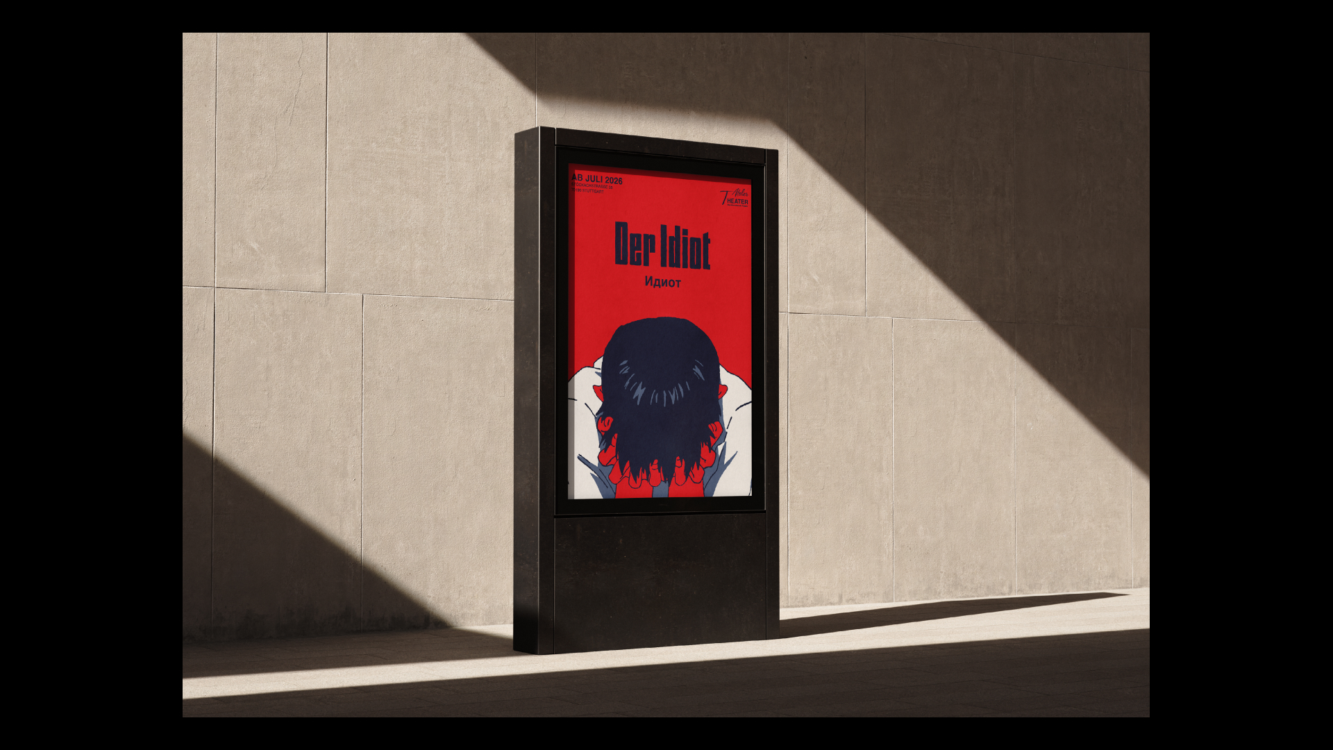 Mockup des fertigen Plakats „Der Idiot“ auf einer Litfaßsäule vor einer Häuserwand